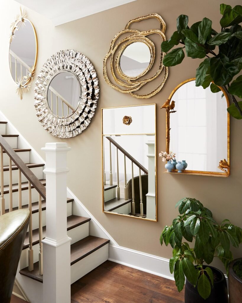 Balanced staircase wall decoration using artwork, mirrors, and negative space